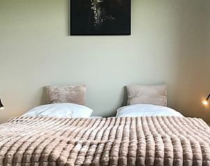 Sfeervolle slaapkamer in Vakantiehuisje in Heijenrath, Limburg met tweepersoonsbed en kunst aan de muur.