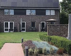 Achtertuin van Vakantiehuisje in Heijenrath, Zuid Limburg met terras en uitzicht op groene omgeving.