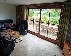 Cozy living room of Holiday home in Mechelen overlooking the green hills of South Limburg, perfect for relaxation.