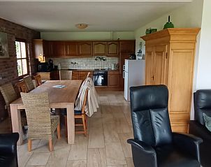 Cozy indoor area of Holiday Home in Mechelen, South Limburg with spacious kitchen and wooden dining table, ideal for family vacations.