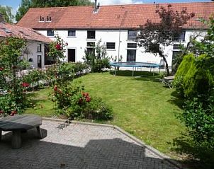 Binnentuin van Landgoed Karsveld appartement in Slenaken, Zuid Limburg met trampoline en bloeiende planten.