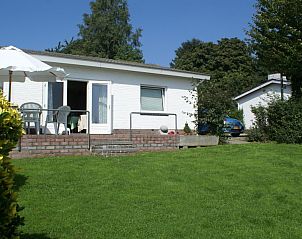 Zonnig terras met parasol bij Domein Hellebeuk, vakantiehuis in Valkenburg, Zuid Limburg.