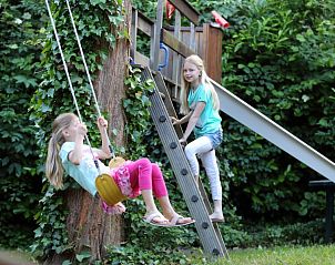 Kinderen spelen op schommel bij Domein Hellebeuk, vakantiehuis in Valkenburg, Zuid Limburg.