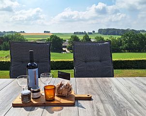 Terras met uitzicht op groene heuvels bij Domein Hellebeuk, vakantiehuis Valkenburg, Zuid Limburg.