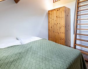 Slaapkamer met dakraam en houten details in Vakantiehuisje in Wijlre, Zuid-Limburg.