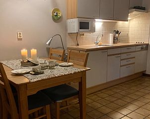 Knusse eetruimte in Vakantiehuisje in Wijlre, Zuid Limburg met houten tafel en kaarsen voor sfeervolle diners.