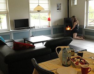 Gezellige woonkamer in Vakantiehuis in Wijlre, Zuid Limburg met houtkachel voor knusse avonden.