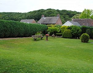 Rustige tuin bij Vakantiehuisje Clermont in Slenaken, Zuid Limburg met zitbanken en groene heg.