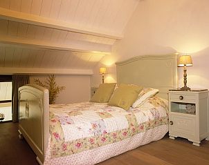 Sfeervolle slaapkamer met houten details in Inkelshoeve a gen Bongerd, vakantiehuis in Epen, Zuid Limburg.