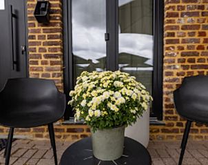 Terrasse mit Blumen und Sthlen im Ferienhaus in Epen, Sdlimburg, ideal fr Sitzgelegenheiten im Freien.