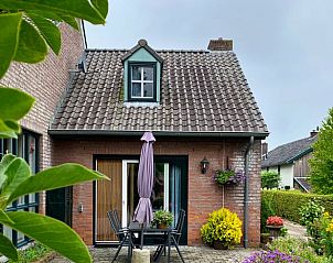 Sonnige Terrasse des Ferienhauses in Epen, Sdlimburg, mit einladender Sitzecke und bunten Blumen.