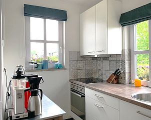 Moderne Kche im Ferienhaus in Epen, Sdlimburg, mit schlichten weien Schrnken und Gartenblick.