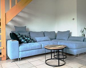 Bequemes Sofa in Cottage in Epen, Sdlimburg, modern eingerichtetes Ferienhaus mit Holztreppe.
