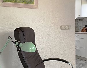 Stilvolle Leseecke im Ferienhaus in Epen, Sdlimburg, mit Designerstuhl und Kunst an der Wand.