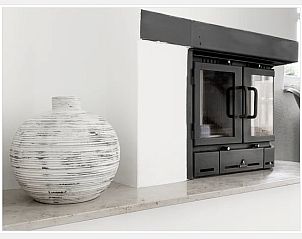 Stilvoller Kamin im Ferienhaus in Epen, Sdlimburg, mit modernen Details und dekorativer Vase.