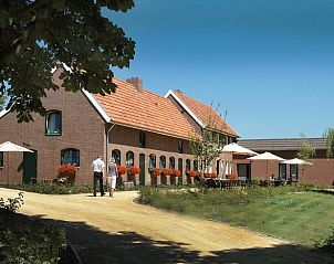 Ferienhaus in Epen in Sdlimburg mit charmanter Backsteinfassade und bunten Blumen in lndlicher Umgebung.