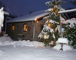Winterse charme bij Vakantiewoning 'in de Boomgaard' in Oud Roosteren, bedekt met sneeuw voor een gezellige Limburgse ervaring.