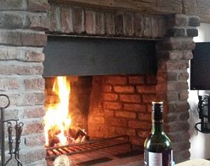 Gezellige open haard in Vakantiewoning 'in de Boomgaard' in Oud Roosteren, perfect voor een warme avond in Midden Limburg.