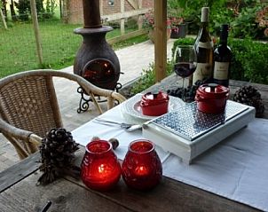 Gezellig diner op de veranda van Vakantiewoning 'in de Boomgaard' in Oud Roosteren, omgeven door de natuur van Midden Limburg.