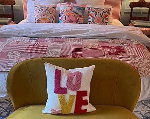 Sfeervolle slaapkamer in Huisje in Mook, Zuid Limburg, met kleurrijke decoraties voor een knusse vakantiewoning ervaring.