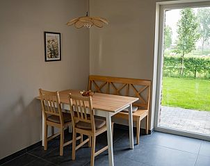 Eethoek in vakantiehuis Wittem, Zuid Limburg, met uitzicht op groene tuin.