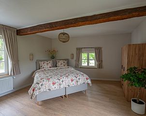 Ruime slaapkamer in vakantiehuis Wittem, Zuid Limburg, met houten balken en veel licht.