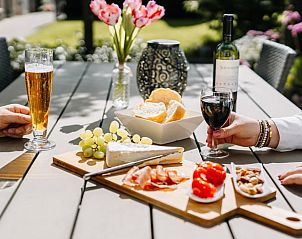Enjoy a relaxing afternoon on the terrace of Holiday Home in Gulpen - Wittem, South Limburg, with wine and snacks in the sun.
