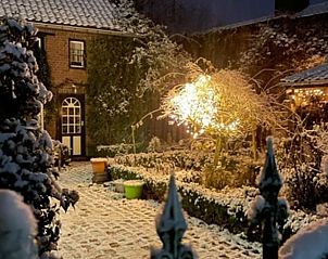 Sfeervol winterlandschap bij Vakantiehuis in Beutenaken, Zuid Limburg, met sneeuw en verlichting.
