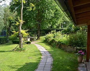 Wandelpad door de tuin van Vakantiehuis in Beutenaken, Zuid Limburg, omringd door groen.