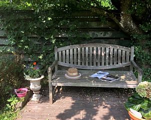 Houten bankje in de tuin van Vakantiehuis in Beutenaken, Zuid Limburg, voor rustmomenten in de natuur.