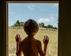 Kind kijkt naar het landschap vanuit Huisje in Wahlwiller, vakantiehuis in Zuid Limburg, met weids uitzicht.