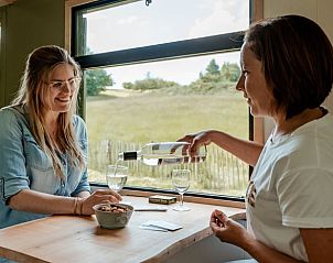 Gasten genieten van een drankje in Huisje in Wahlwiller, vakantiehuis in Zuid Limburg, met uitzicht op de natuur.