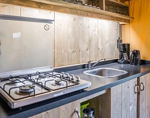 Ruime binnenruimte van Safaritent 6B in Mierlo, De Peel, Noord Brabant, met gezellige houten eettafel en comfortabele slaapruimte.