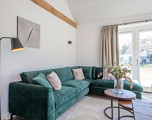 Stijlvolle woonkamer in Villa 8B, vakantiehuis in Someren, De Peel, Noord Brabant met comfortabele bank en uitzicht op de tuin.