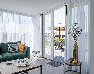 Lichte woonkamer van Wellnessvilla 6B in Someren, De Peel, Noord Brabant met uitzicht op terras en tuin.