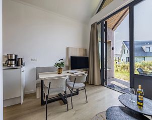 Eethoek en open keuken in 4-persoonslodge 4B5, Someren, De Peel, met uitzicht op het terras.