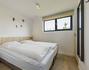 Slaapkamer met tweepersoonsbed in 4-persoonslodge 4B5, Someren, De Peel, met raam voor uitzicht.