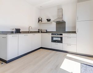 Open woon- en eetruimte in 4-persoonsbungalow 4L2, Someren, De Peel, Noord Brabant met moderne inrichting en kunst aan de muur.