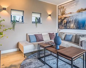 Gezellige woonkamer in 8-persoonsbungalow | 8L, Someren, met comfortabele bank en kunstwerk.