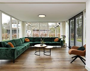 Ruime woonkamer met groene bank in vakantiewoning Someren, Noord Brabant.