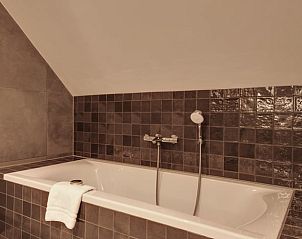 Moderne badkamer met ligbad in Vakantiehuis in Milheeze, De Peel, voor ultieme ontspanning.