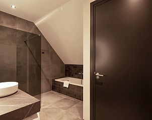 Ruime badkamer met douche en bad in Vakantiehuis in Milheeze, De Peel, ideaal voor comfort.