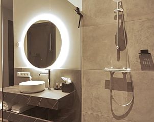 Stijlvolle badkamer in Vakantiehuis in Milheeze, Noord Brabant, met verlichte spiegel en regendouche.