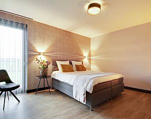 Gezellige slaapkamer met bloemen in Huisje in Milheeze, perfect voor rust in De Peel, Noord Brabant.