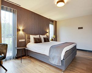 Slaapkamer met bureau en uitzicht in Huisje in Milheeze, voor een serene vakantie in De Peel, Noord Brabant.