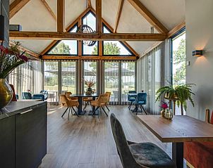 Gezellige eetruimte in Huisje in Milheeze, vakantieaccommodatie in De Peel, met grote ramen en uitzicht op de tuin.