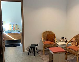 Gezellige zithoek met rieten stoelen in Vakantiehuis in Deurne, perfect voor ontspanning in De Peel, Noord Brabant.