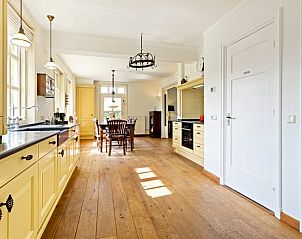 Ruime keuken in Vakantiehuisje in Deurne, Noord Brabant, met houten vloeren en veel lichtinval, ideaal voor een ontspannen verblijf.