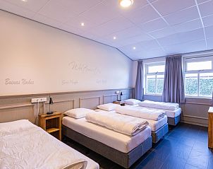 Ruime slaapkamer met meerdere bedden in De Schuurherd en de Hoeve, ideaal voor families.