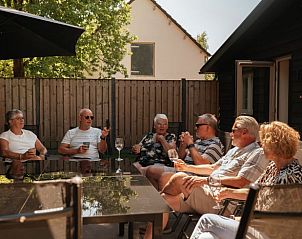 Groep geniet van gezellig samenzijn op het terras van Vakantiehuisje in Bergeijk.